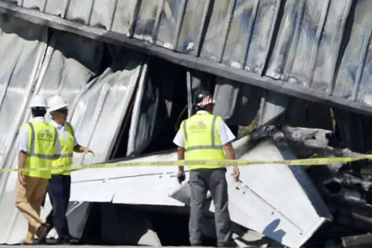 Peritos no local do acidente do bimotor Cessna em um hangar do aeroporto de Santa Monica, na Califórnia (Kevork Djamsezian/Reuters)