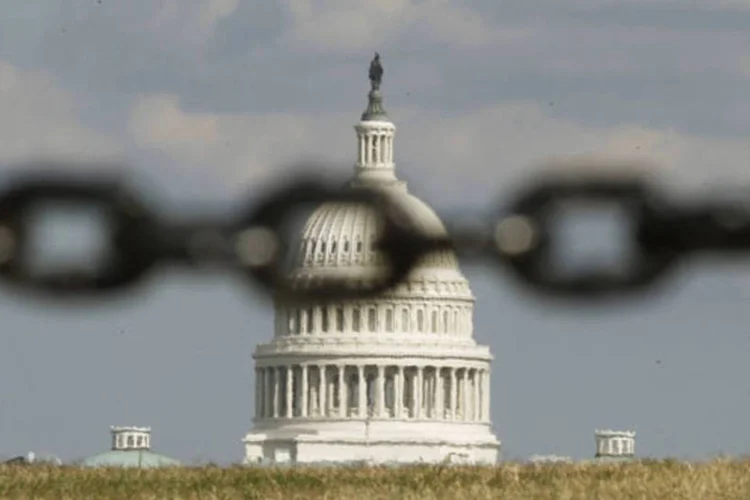 
	Capit&oacute;lio, sede do Congresso dos EUA, &eacute; visto atrav&eacute;s de uma corrente, em Washington: o&nbsp;governo federal americano est&aacute; parcialmente paralisado desde ter&ccedil;a-feira em consequ&ecirc;ncia de uma disputa pol&iacute;tica a respeito do or&ccedil;amento de 2014
 (Kevin Lamarque/Reuters)