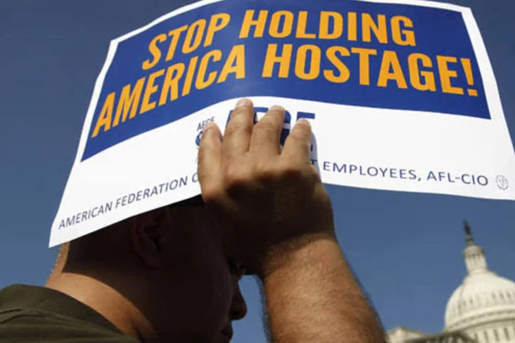 Trabalhadores federais participam de uma manifestação em frente ao Congresso contra a paralisação do Governo, em Washington (Jonathan Ernst/Reuters)