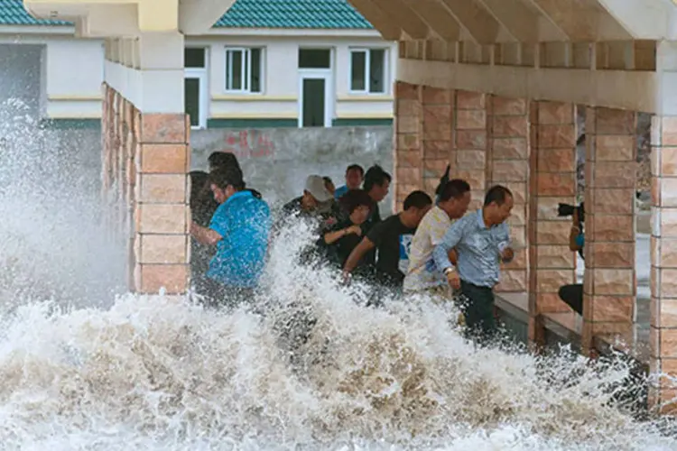 
	Pessoas tentam se esquivar de ondas provocadas pelo tuf&atilde;o Fitow na China: 574 mil pessoas foram evacuadas
 (REUTERS/China Daily)
