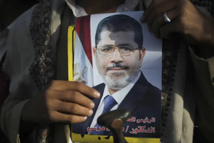 Manifestante pró-democracia segura pôster do presidente deposto Mohamed Mursi durante protesto (Khaled Abdullah/Reuters)