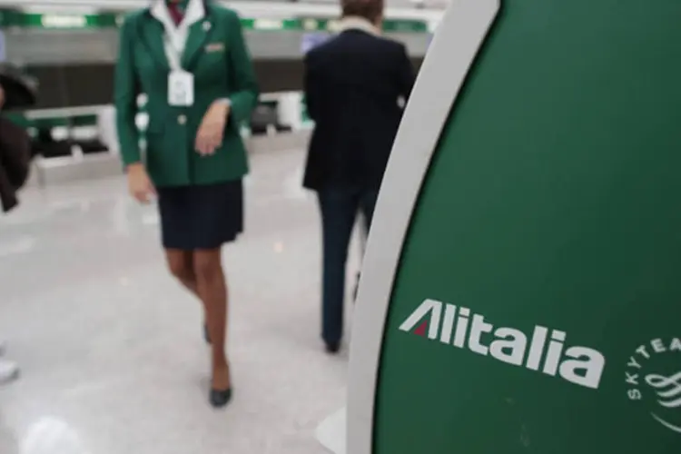 
	Funcion&aacute;ria da companhia a&eacute;rea Alitalia passa por uma m&aacute;quina de check-in autom&aacute;tico no aeroporto de Fiumicino, em Roma
 (Tony Gentile/Reuters)