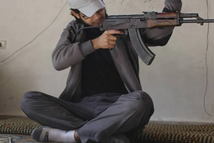 Combatente do Exército Sírio Livre inspeciona sua arma, na área de Jabal al-Akrad, província de Latakia, Síria (Khattab Abdulaa/Reuters)