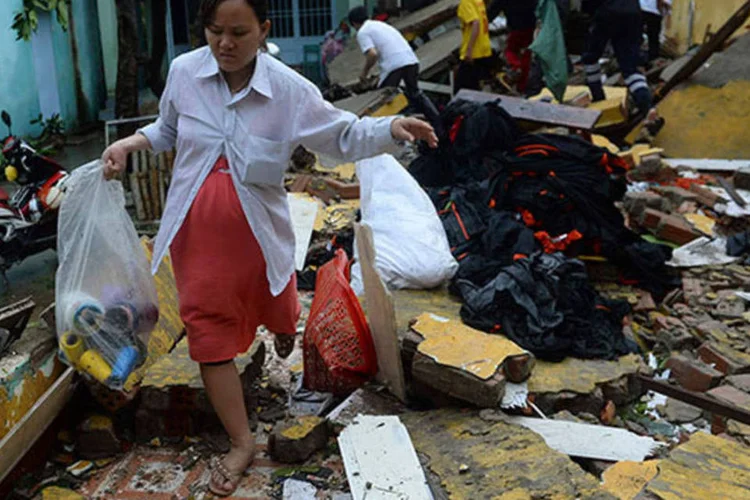Moradores recolhem o que sobrou de seus lares após a passagem do tufão Nari no Vietnã (REUTERS/Duc Hien)