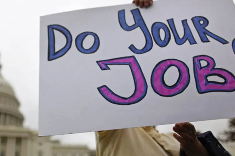 Funcionário público federal norte-americano faz protesto com cartaz "Façam seu trabalho" em frente ao Capitólio, a sede do Congresso dos Estados Unidos, em Washington (Jonathan Ernst/Reuters)