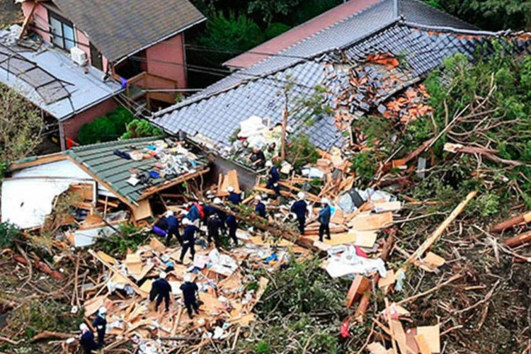 
	Equipe de resgate procura sobreviventes em destro&ccedil;os de casa que desabou ap&oacute;s passagem do tuf&atilde;o Wipha no Jap&atilde;o: o fen&ocirc;meno provocou fortes ventos de at&eacute; 160 km/h&nbsp;
 (REUTERS/Kyodo)