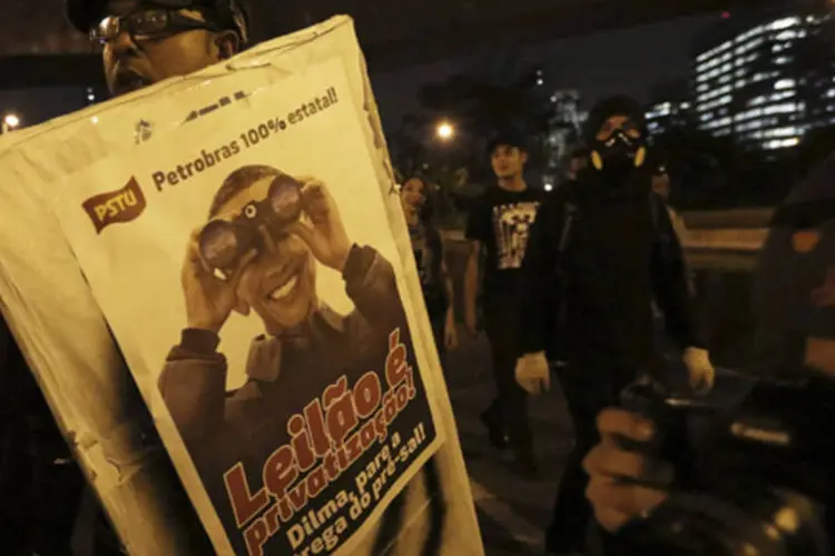 Manifestante segura cartaz contra o leilão de campos de petróleo durante protesto em São Paulo (Nacho Doce/Reuters)