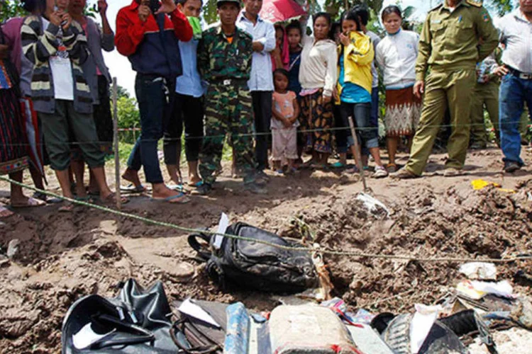 Cidadãos observam restos de avião que caiu ontem em Laos, na Tailândia, devido ao mau tempo (REUTERS/Chaiwat Subprasom)