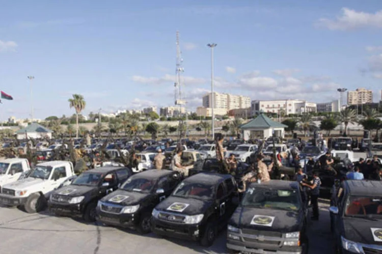 
	Grupos de revolucion&aacute;rios e seus ve&iacute;culos visto em Tripoli: &eacute; a segunda vez nesta semana que a capital&nbsp;&eacute; abalada por confrontos
 (Ismail Zitouny/Reuters)