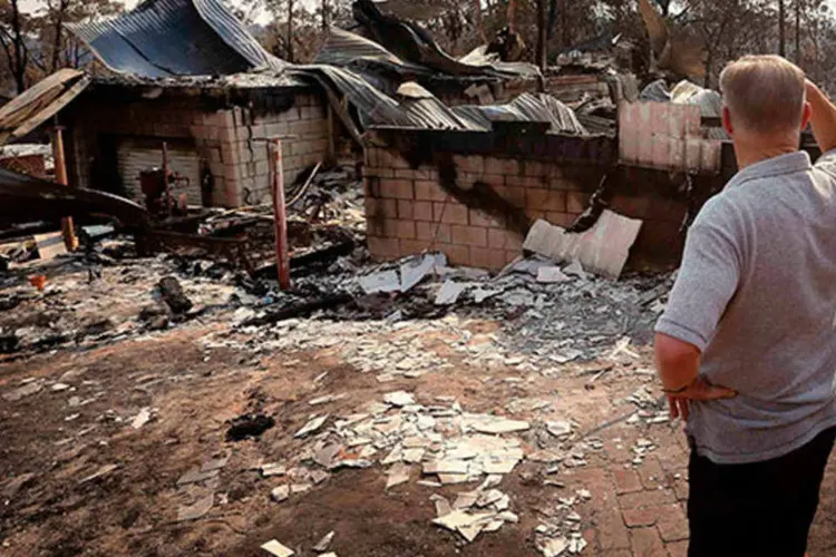
	Homem observa sua casa destru&iacute;da ap&oacute;s inc&ecirc;ndio na Austr&aacute;lia: mais de 200 casas foram arrasadas pelas chamas no oeste de Sydney
 (REUTERS/David Gray)