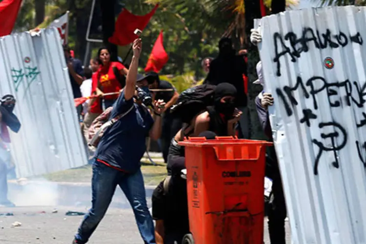 Manifestantes mascarados entram em confronto com a polícia antes do leilão do Campo de Libra no Rio (REUTERS/Sergio Moraes)