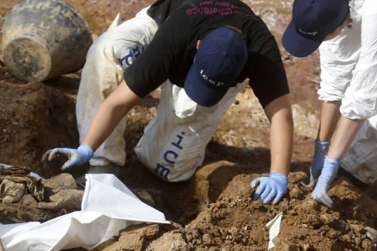 Especialistas forenses do Instituto de Pessoas Desaparecidas da Bósnia trabalham em uma vala comum na vila de Tomasica (Dado Ruvic/Reuters)