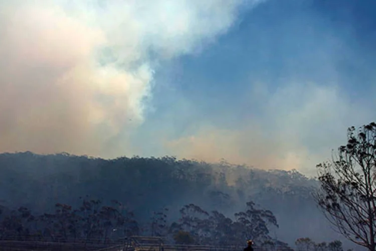 
	Morador observa inc&ecirc;ndio se aproximando de casas na Austr&aacute;lia: segundo as previs&otilde;es, as temperaturas devem aumentar nos pr&oacute;ximos dias
 (REUTERS/David Gray)