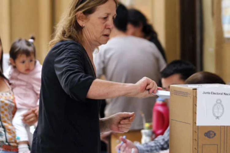 Mulher deposita o seu voto durante as eleições legislativas da Argentina, em Buenos Aires (Marcos Brindicci/Reuters)