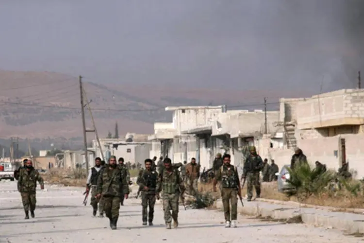 Membros de forças leais ao presidente da Síria, Bashar al-Assad, caminham na cidade de Safira (George Ourfalian/Reuters)