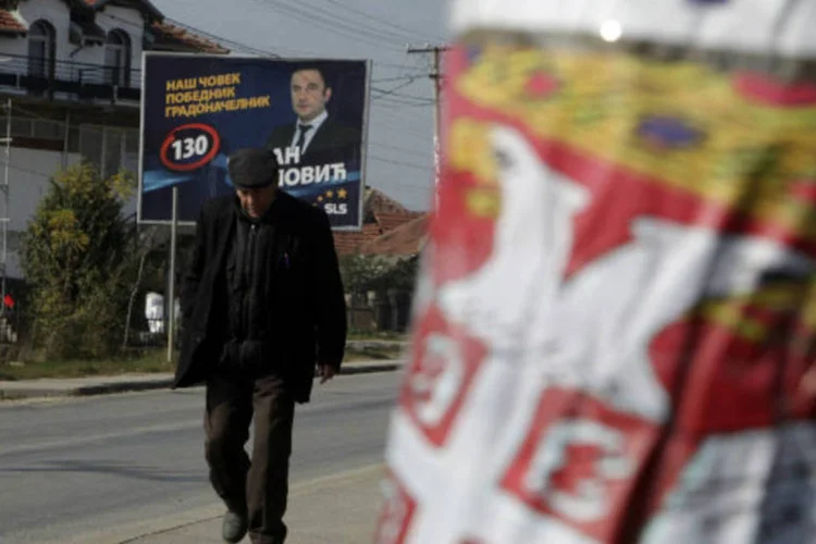 Sérvio do Kosovo passar por posters da campanha eleitoral em Gracanica, que é habitada por sérvios (Hazir Reka/Reuters)