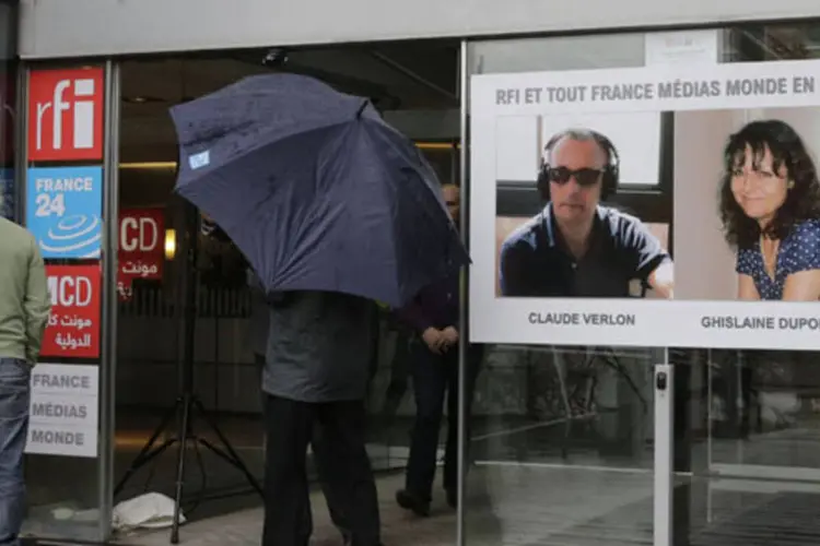 Imagens dos jornalistas franceses Ghislaine Dupont e Claude Verlon na entrada da sede do Radio France Internationale, próximo de Paris (Jacky Naegelen/Reuters)