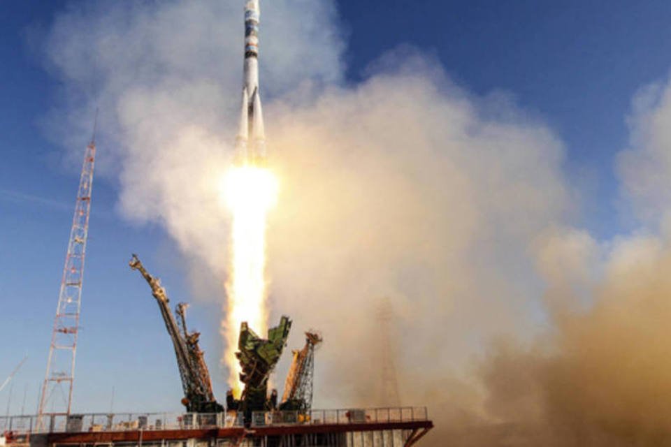 Tripulação espacial volta à Terra com tocha olímpica