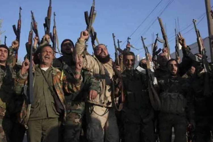 Forças leais ao presidente Bashar al-Assad comemoram após conquistas na zona rural de Alepo, na Síria (George Ourfalian/Reuters)