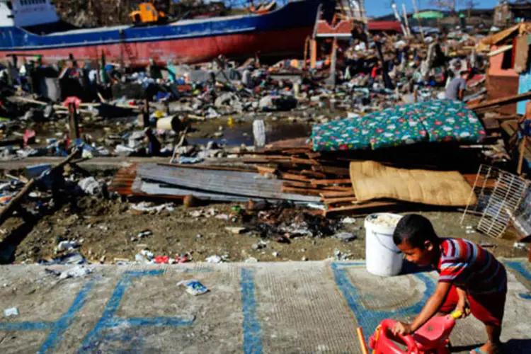 
	Garoto brinca em frente &agrave; sua casa, que foi destru&iacute;da pelo tuf&atilde;o Haiyan, nas Filipinas: continuam as tarefas de reconstru&ccedil;&atilde;o
 (REUTERS/Damir Sagolj)