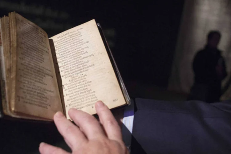 David Redden, CEO de Livros e Manuscritos da Sotheby's, com uma cópia do "The Bay Psalm Book" na casa de leilões de Nova York (Carlo Allegri/Reuters)