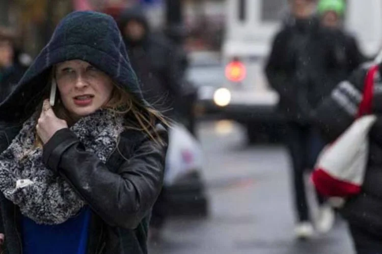 Mulher caminha enquanto um chuva começa a cair na cidade de Nova York, nos Estados Unidos (Brendan McDermid/Reuters)