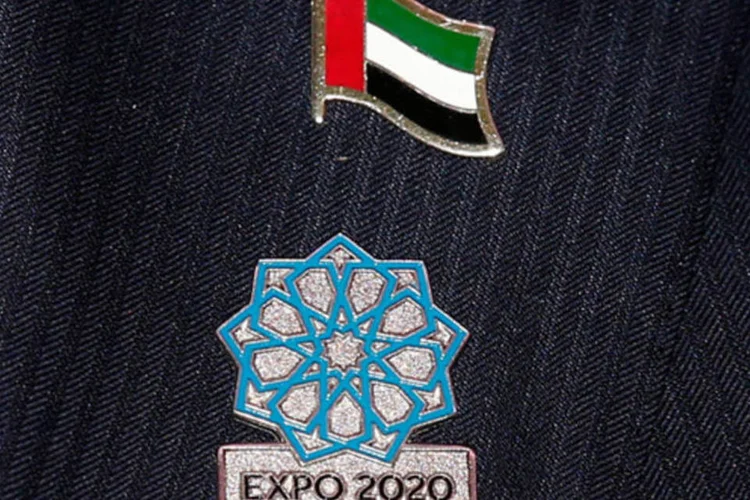 Bottom promocional da Expo 2020 e bandeira dos Emirados Árabes: exposições mundiais são realizadas a cada cinco anos, durante um período de seis meses (Benoit Tessier/Reuters)