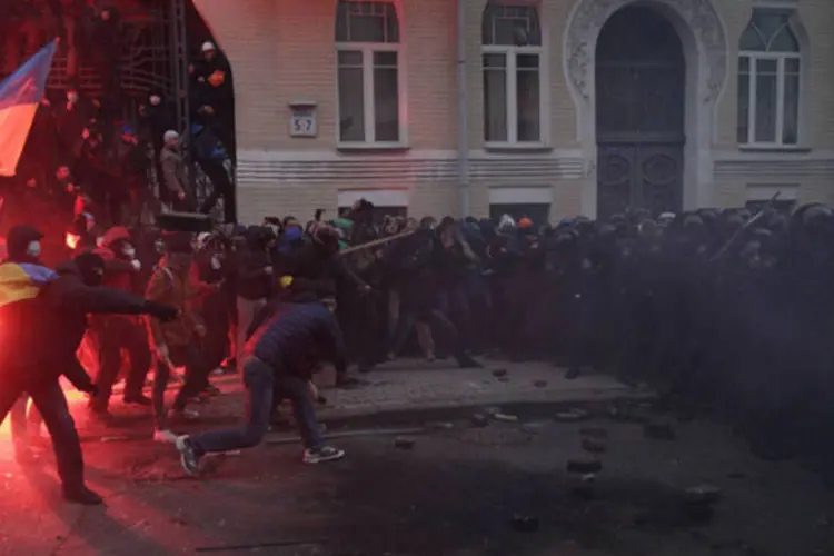 Manifestantes tentam romper bloqueio policial: tropa de choque bloqueou as ruas que dão acesso ao gabinete presidencial, confrontando centenas de manifestantes por trás das barreiras metálicas (Stoyan Nenov/Reuters)