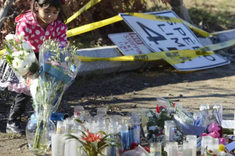 Menina coloca flores no local do acidente de carro onde o ator Paul Walker foi morto na região de Santa Clarita, em Los Angeles (Phil McCarten/Reuters)