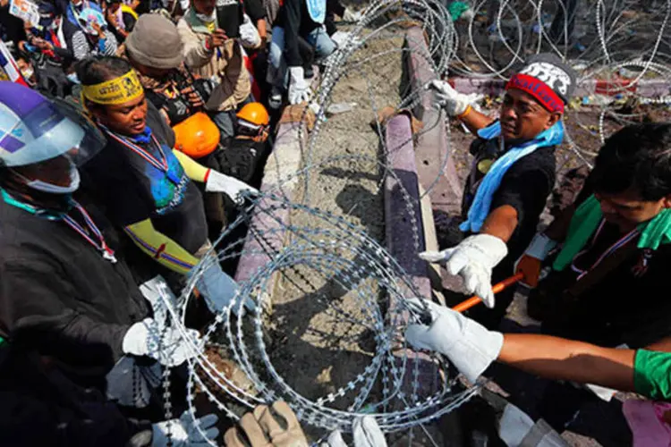Manifestantes removem o arame farpado da entrada da sede policial em Bangcoc, na Tailândia (REUTERS/Damir Sagolj)