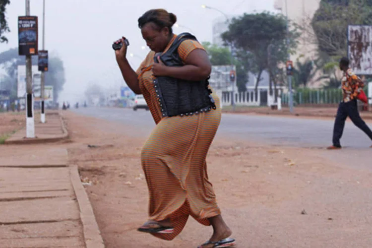 Mulher foge de disparo de arma de fogo em Bangui: República Centro-Africana vive em situação caótica desde que rebeldes, principalmente muçulmanos, tomaram o poder, em março (Emmanuel Braun/Reuters)