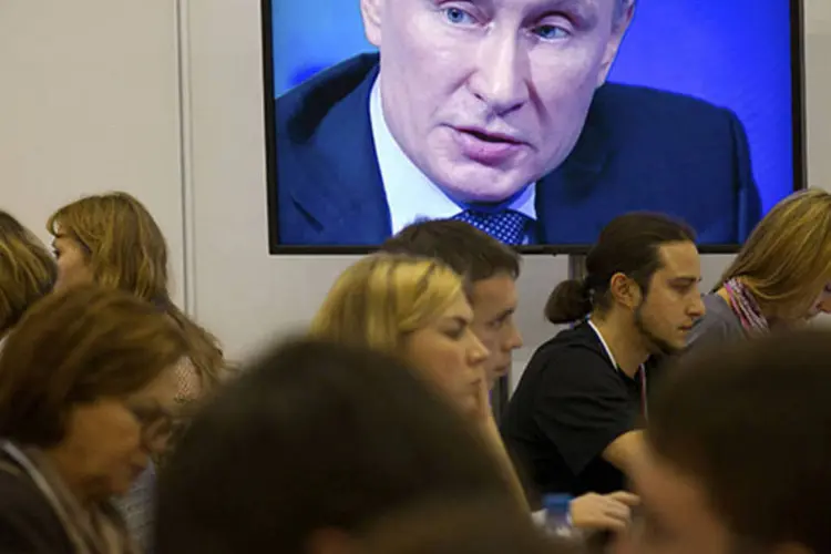Repórteres assistem a uma teleconferência do presidente russo, Vladimir Putin, durante encontro do seu grupo em 2011 (Alexander Zemlianichenko/Reuters)