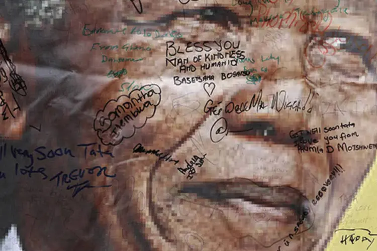 
	Poster com mensagens para Nelson Mandela em uma rua de Soweto, onde o l&iacute;der morou quando vivia na cidade: grande parte das autoridades j&aacute; estar&aacute; em Johannesburgo amanh&atilde;
 (Siphiwe Sibeko/Reuters)