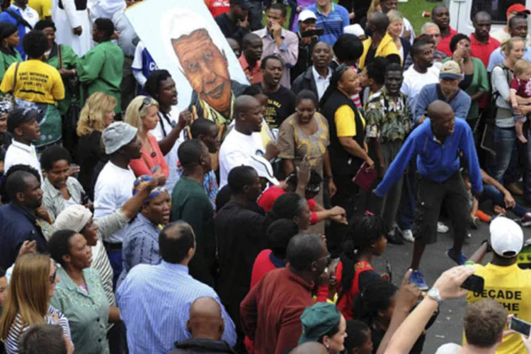 Pessoas com foto de Mandela na manhã de sexta: na capital, Pretória, em Johanesburgo e Cape Town, muitos ainda estavam em choque pela morte do homem que foi um símbolo mundial (Reuters)