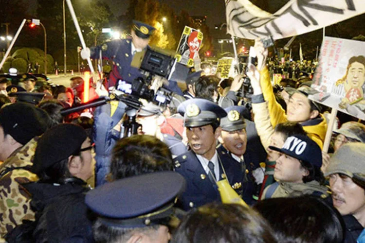 Manifestantes durante protesto contra lei de sigilo durante confronto com a polícia em frente ao prédio do parlamento, em Tóquio (Kyodo/Reuters)