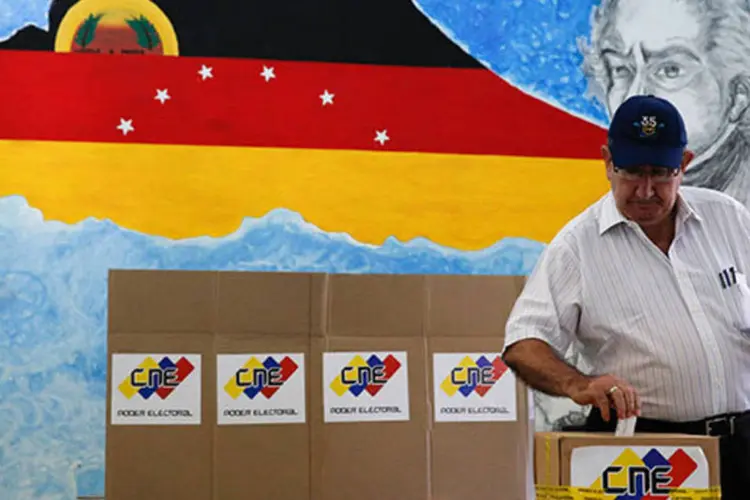Homem deposita voto em urna durante eleições municipais na Venezuela (REUTERS/Carlos Garcia Rawlins)