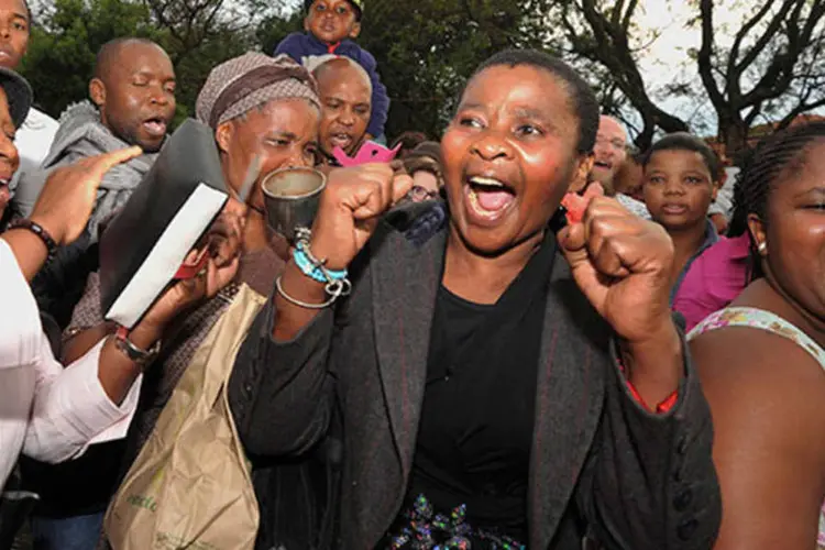 Pessoas cantam e dançam em homenagem a Nelson Mandela (REUTERS/Ihsaan Haffejee)