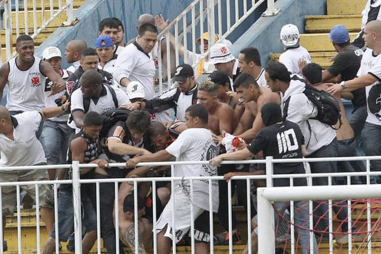 
	Torcedores do Vasco agridem torcedor do Atl&eacute;tico Paranaense durante briga generalizada em Joinville, durante partida do Campeonato Brasileiro
 (Carlos Moraes/Agencia O Dia/Reuters)