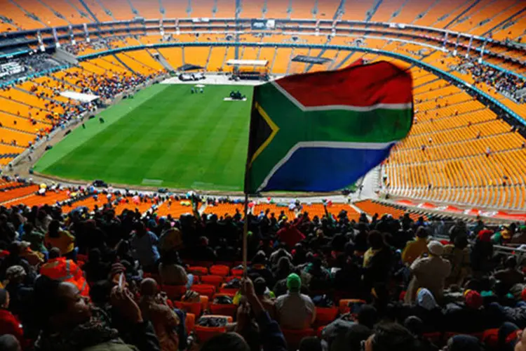 Bandeira da África do Sul é levantada no Estádio Soccer City, à medida em que as pessoas chegam para a homenagem a Nelson Mandela (REUTERS/Yannis Behrakis)
