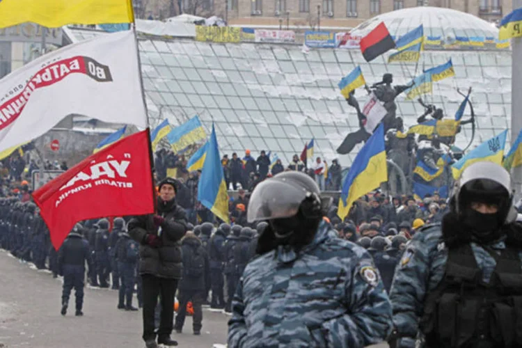 Manifestantes a favor de uma maior integração com a Europa cercados por um cordão de policiais na Praça da Independência, em Kiev (Gleb Garanich/Reuters)