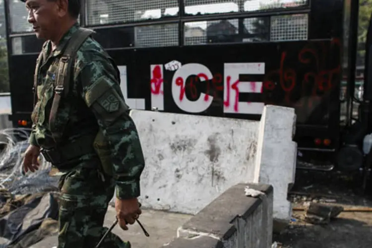 Soldado é visto em frente a um caminhão de polícia depredado em Bangcoc, na Tailândia (Athit Perawongmetha/Reuters)
