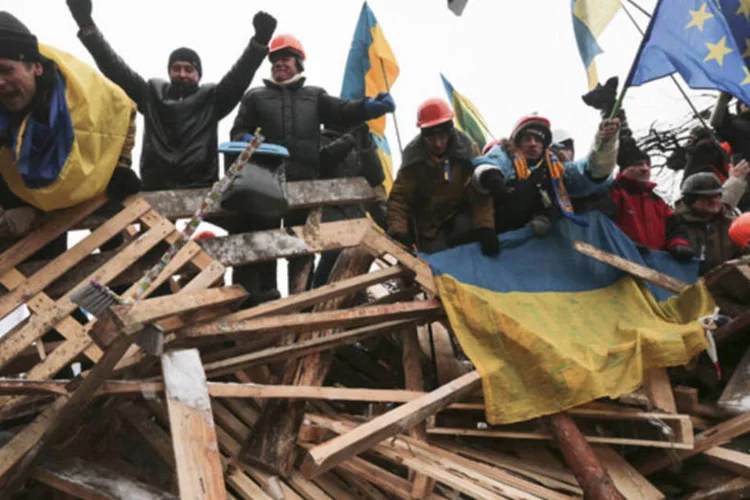 Manifestantes favoráveis à integração da Ucrânia com a União Europeia comemoram o recuo da polícia, na Praça Independência, em Kiev, na Ucrânia (Konstantin Chernichkin/Reuters)