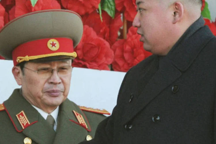 
	L&iacute;der norte-coreano Kim Jong Un (&agrave; direita) passa por seu tio, Jang Song Thaek, durante evento militar em Pyongyang, na Coreia do Norte
 (Kyodo/Reuters)