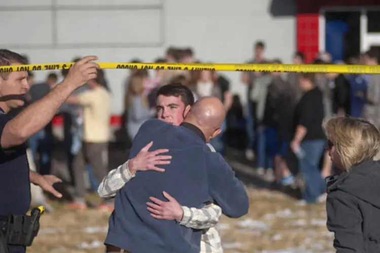 Estudantes se reúnem com seus pais perto do colégio Arapahoe, depois que um aluno abriu fogo na escola em Centennial, no Colorado, Estados Unidos (Evan Semon/Reuters)