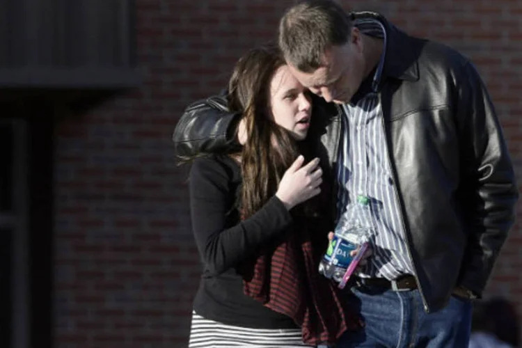 Estudantes se reúnem com seus pais perto do colégio Arapahoe, depois que um aluno abriu fogo na escola em Centennial, no Colorado, Estados Unidos (Evan Semon/Reuters)