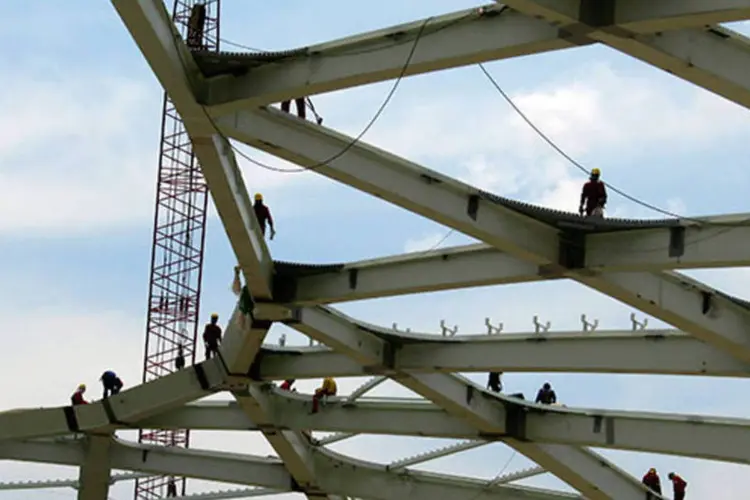 Operários são vistos na parte de cima da estrutura do Estádio Arena Amazônia, um dos estádios da Copa do Mundo de 2014, em Manaus (REUTERS/Gary Hershorn)