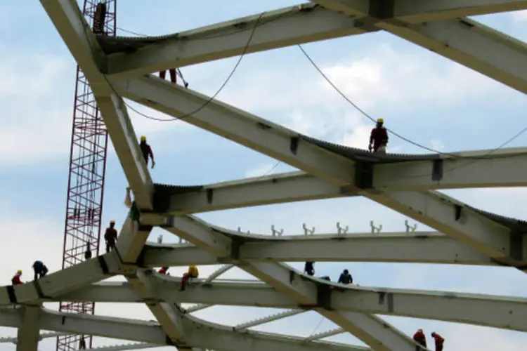 Operários são vistos na parte de cima da estrutura do Estádio Arena Amazônia, um dos estádios da Copa do Mundo de 2014, em Manaus (Gary Hershorn/Reuters)