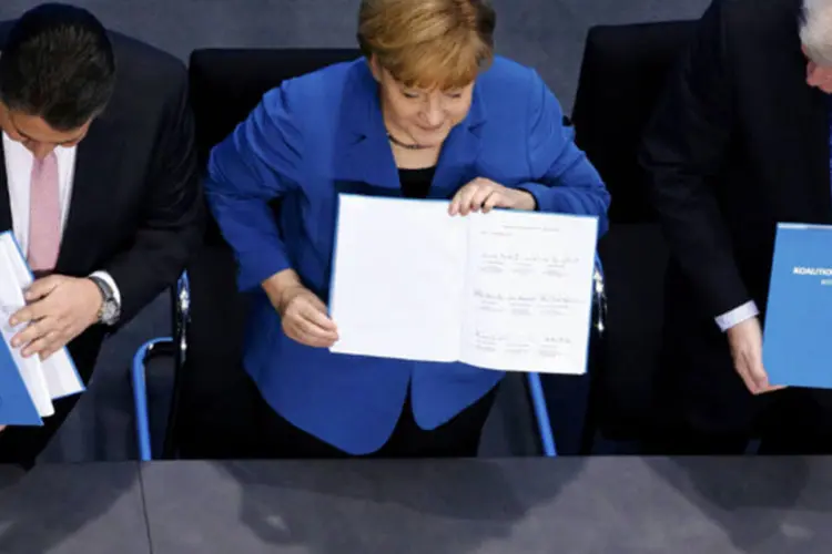 
	Angela Merkel durante cerim&ocirc;nia de assinatura do tratado para um governo de coaliz&atilde;o com Horst Seehofer, l&iacute;der da Uni&atilde;o Social Crist&atilde;, e Sigmar Gabriel, l&iacute;der do Partido Social Democrata
 (Tobias Schwarz/Reuters)