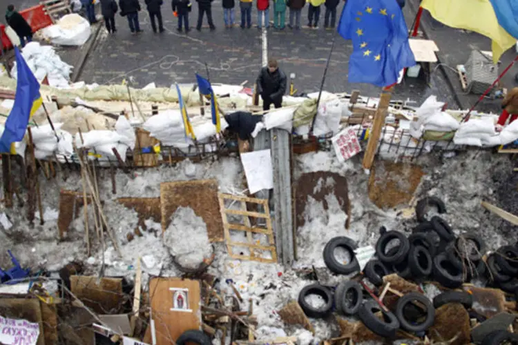 Manifestantes a favor de uma maior integração com a Europa se perfilam perto de uma barricada na Praça da Independência, em Kiev (Marko Djurica/Reuters)