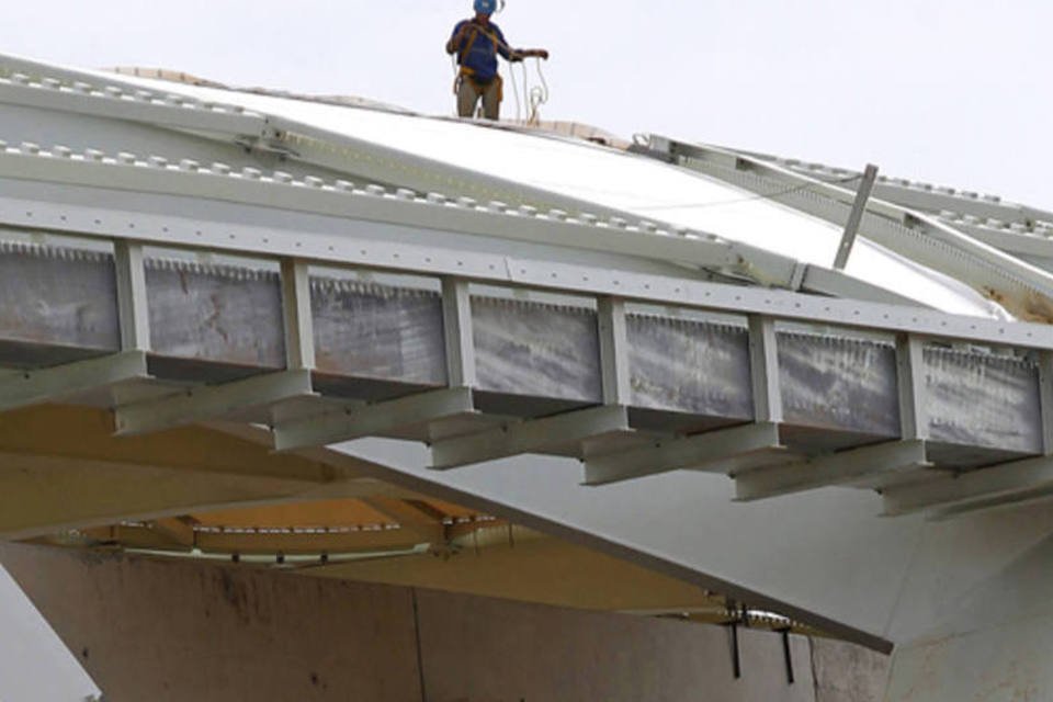 Operários são vistos na parte de cima da estrutura do Estádio Arena Amazônia, um dos estádios da Copa do Mundo de 2014, em Manaus (Bruno Kelly/Reuters)